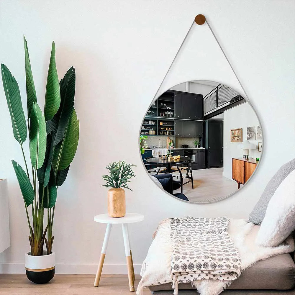 Espelho redondo Adnet com alça de couro decorando sala moderna